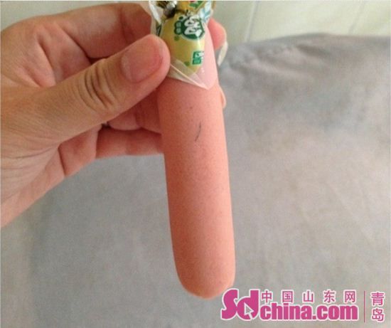 图为金锣肉粒多香肠头发状异物。(图片来源:中国山东网)