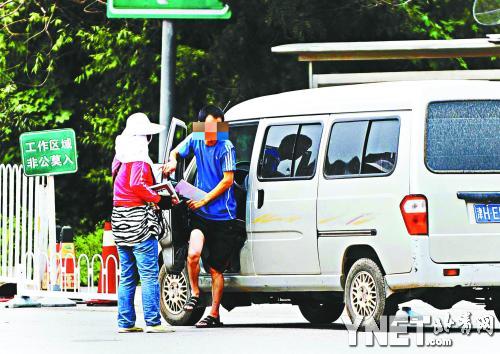 一女子在向外地车司机兜售假进京证摄影/本报记者 袁艺